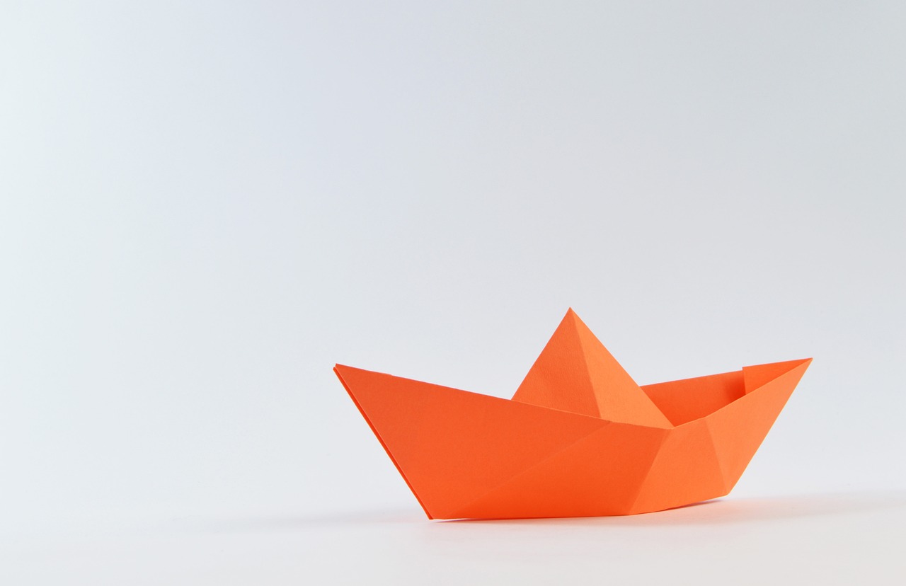 Orange paper boat made from paper